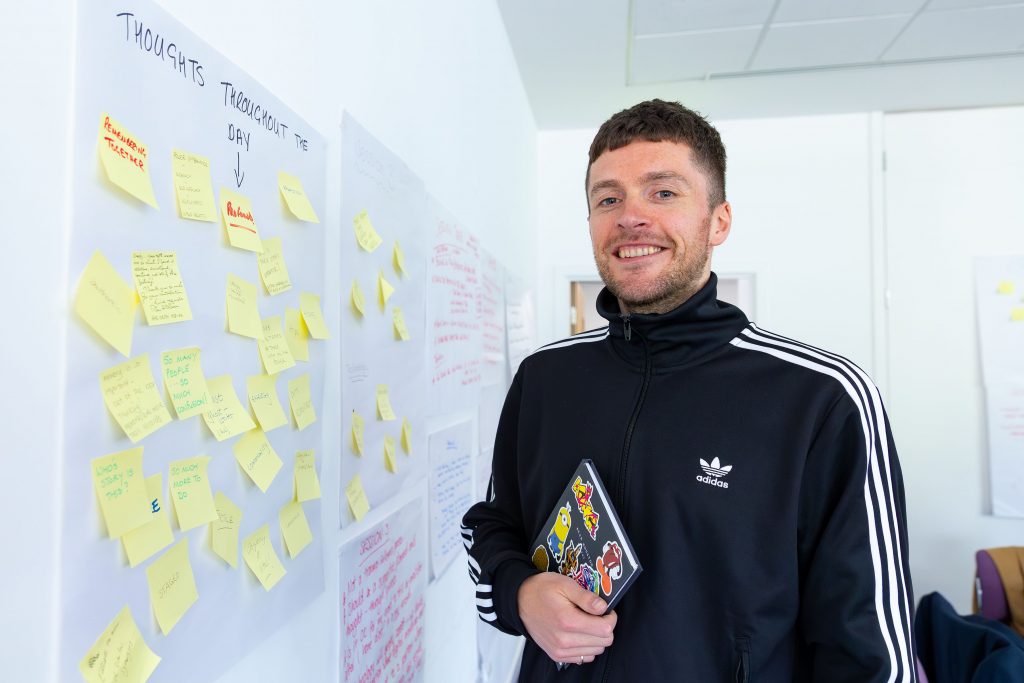 Photo of Craig standing beside flip charts with post it notes